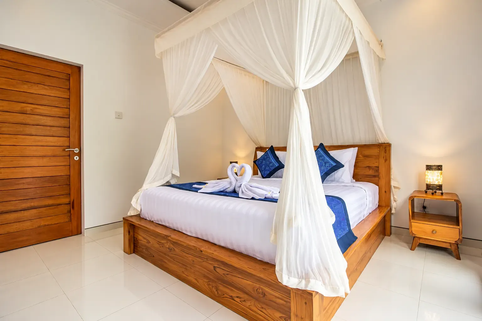 Cama con dosel Cahyana House con lámparas de noche.