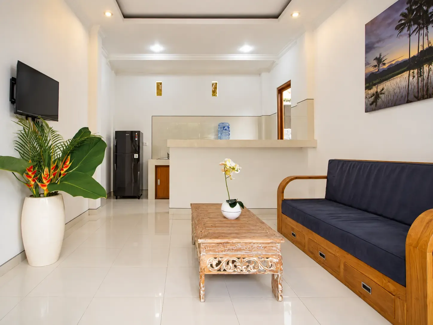 Sala de estar Cahyana House con sofá, mesa de centro y televisor.