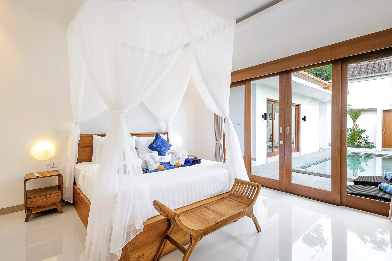 Habitación Cahyana Tibuah con puertas de cristal que dan a la piscina.